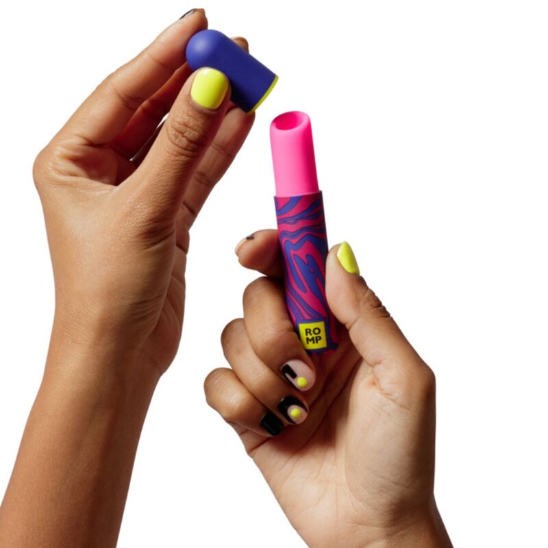 Camuflagem em Bolsa: O estimulador posicionado ao lado de artigos de maquilhagem e perfumes reais, demonstrando como se integra de forma invisível.