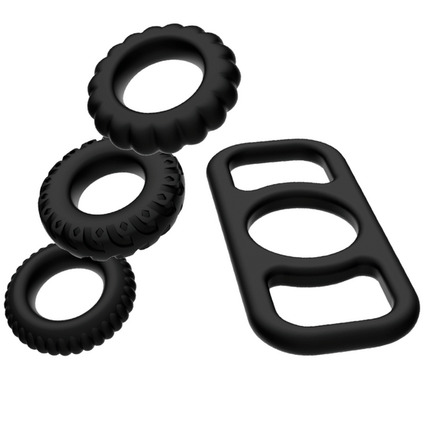 Conjunto de Anéis Addicted Toys: Quatro anéis penianos e escrotais de silicone premium preto dispostos em linha.