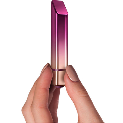 Vibrador de batom prateado Trema da Diamora, posicionado ao lado de maquilhagem para mostrar discrição.