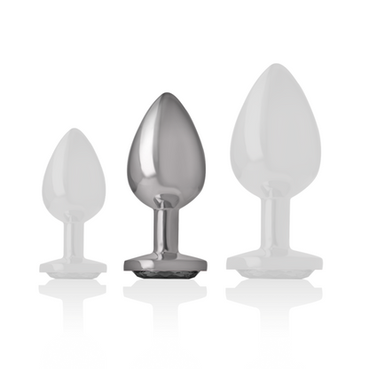 Joia Anal Intense com Cristal Preto M: Fotografia de estúdio com iluminação premium em fundo escuro, focando no plug anal de alumínio polido de tamanho M, exibindo o reflexo espelhado do metal e o cristal negro facetado na base. Diamora
