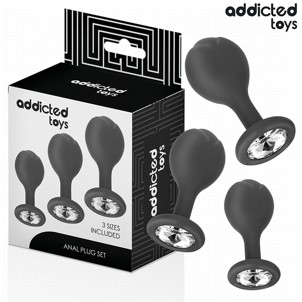 Kit de 3 Plugs Anais de Metal Addicted Toys: Fotografia comercial sofisticada exibindo os três plugs de alumínio médico alinhados por ordem crescente de tamanho (S, M e L), destacando o acabamento espelhado e os cristais brilhantes nas bases.