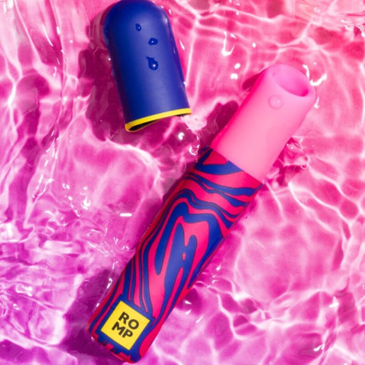 Vibrador Batom ROMP Whisper: Estimulador clitoridiano discreto nas cores bordô e ouro, exibido na vertical com a tampa aberta ao lado.